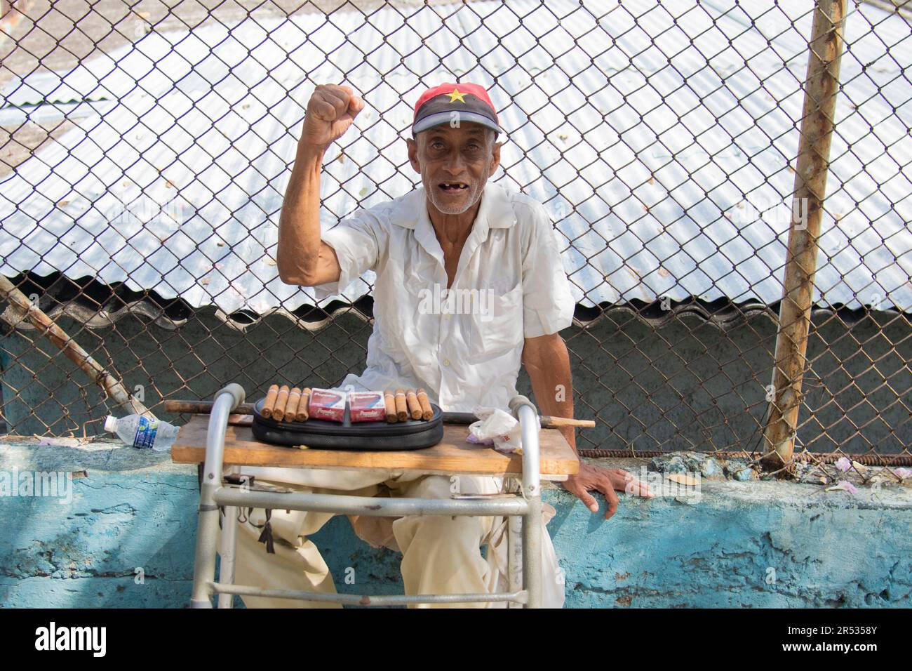 Ein älterer Mann lächelt, während er Zigaretten und Zigarren in einem kleinen Laden in Havanna, Kuba, verkauft. Stockfoto