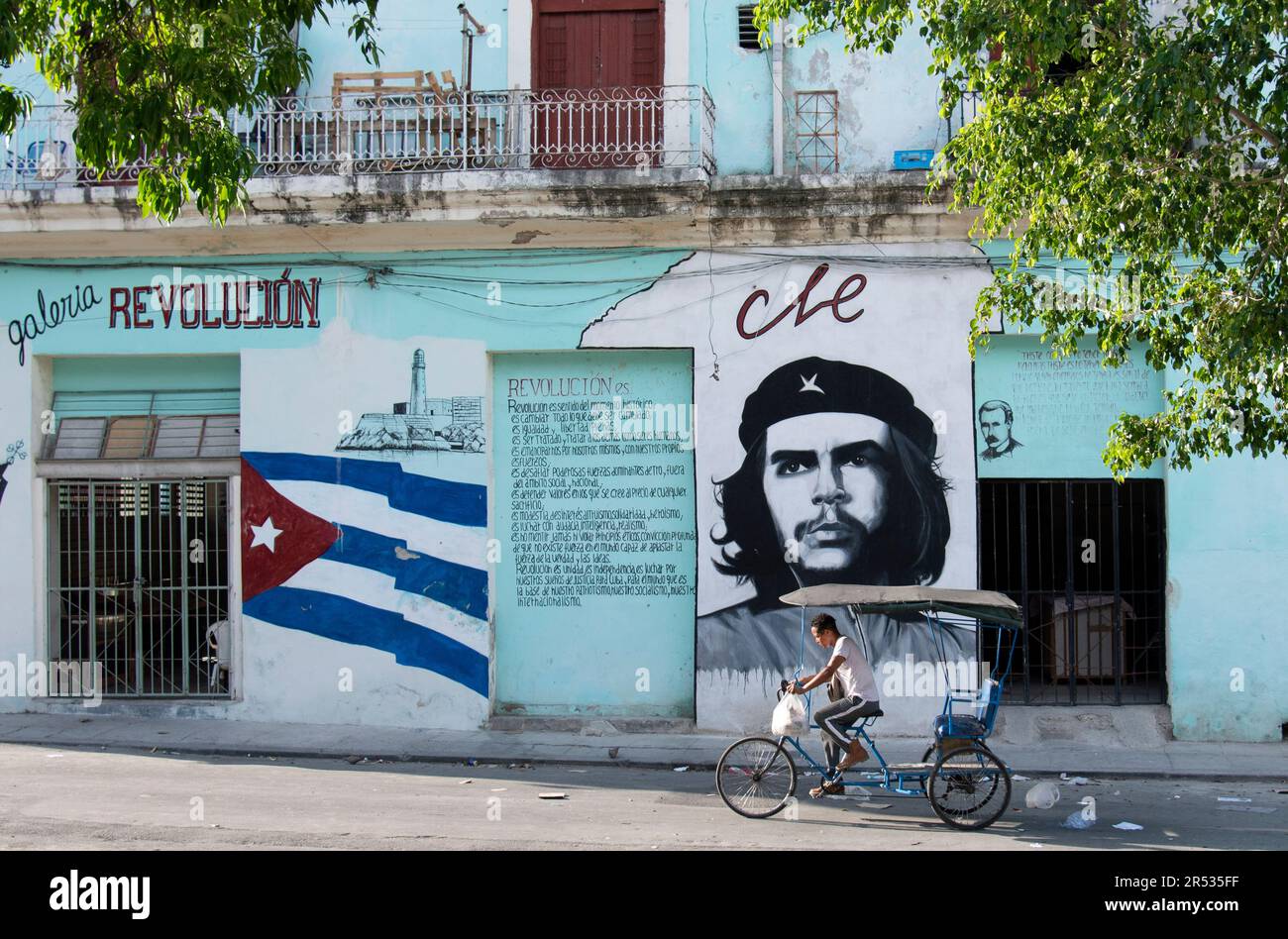Straßengemälde von Che Guevara in Havanna, Kuba, mit einem Fahrradfahrer. Stockfoto