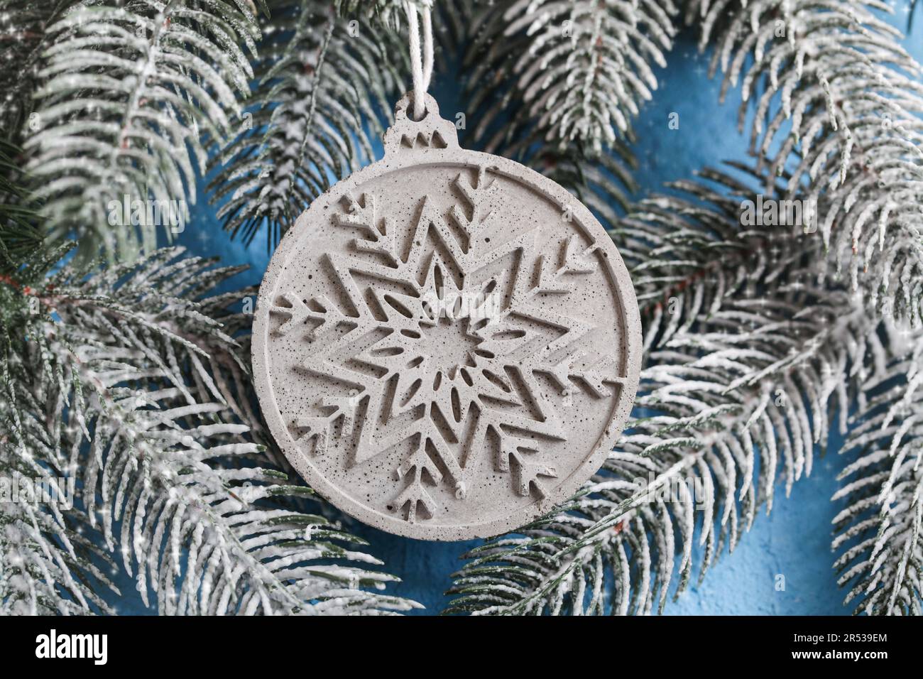 Schneeflockenbeton. Verbesserte Frostbeständigkeit beim Aushärten. Gips-Weihnachtsball auf dem weihnachtsbaum. Neujahrshintergrund für das Gebäude von Stor Stockfoto