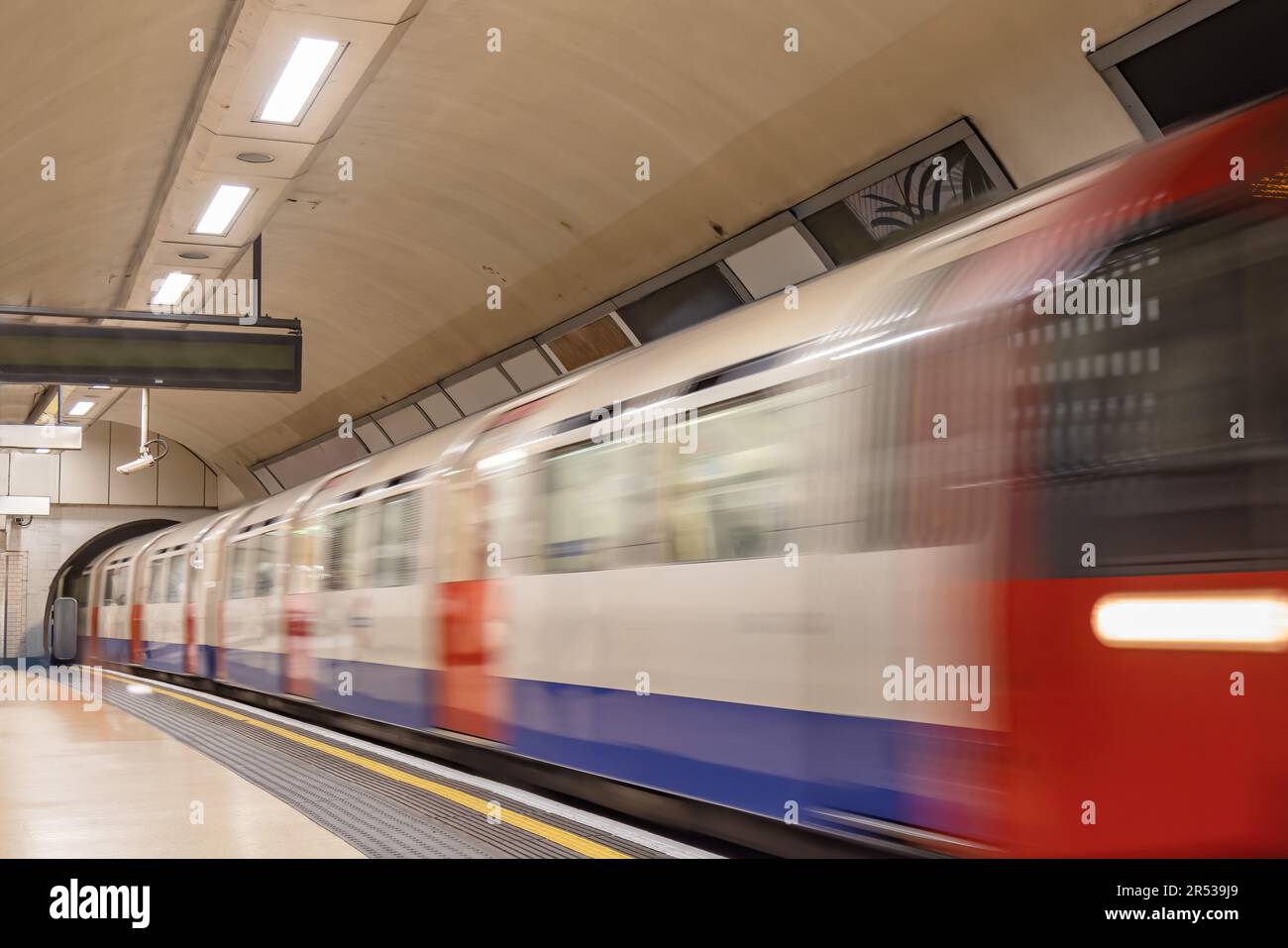 Langzeitbelichtungsfotografie eines Zuges, der auf einem unterirdischen Bahnsteig ankommt Stockfoto