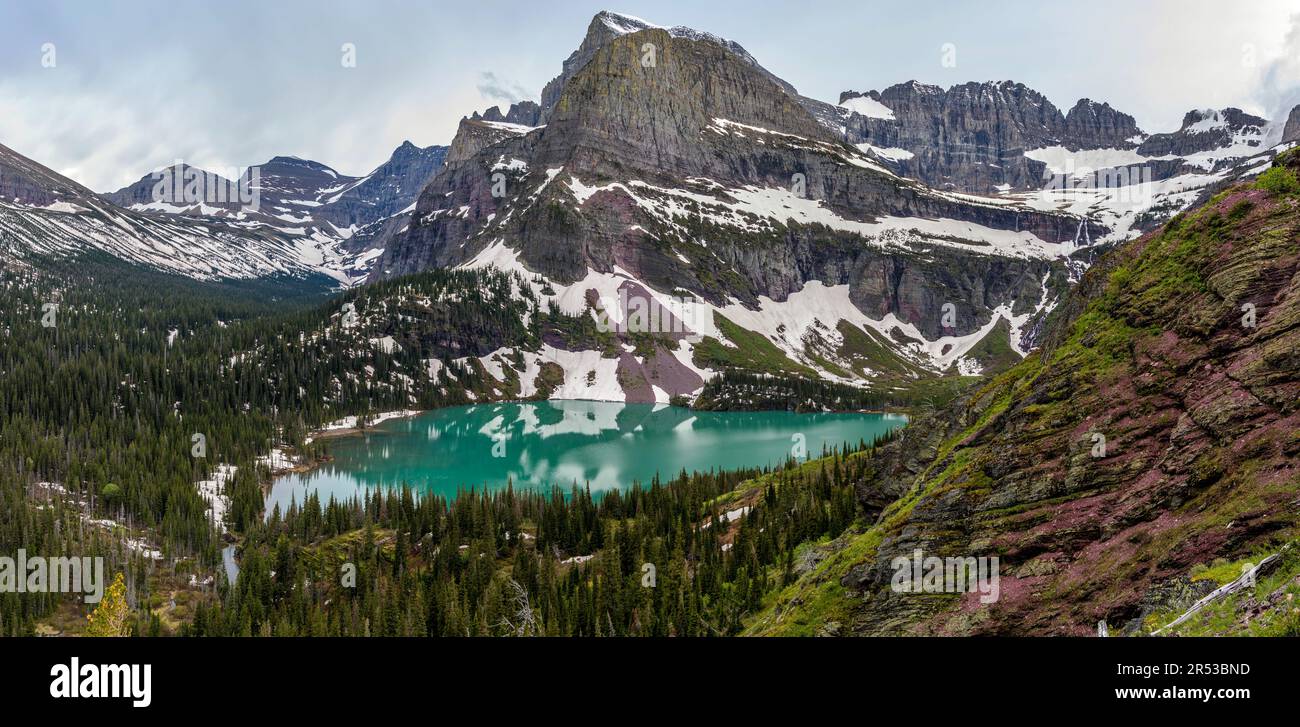 Grinnell Lake - am Frühlingsabend scheint das Sonnenlicht auf den farbenfrohen Grinnell Lake und den zerklüfteten Mt. Gould und Angel Wing, Many Glacier, Glacier National Park, MT. Stockfoto