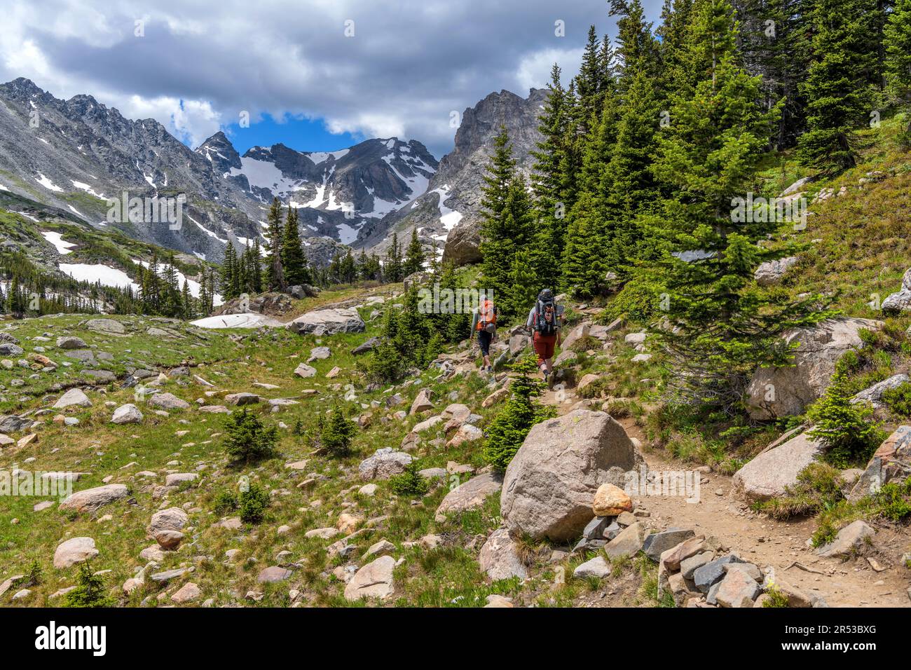 Mountain Trail - zwei gut ausgestattete Bergsteiger, die an einem sonnigen Sommertag auf dem Pawnee Pass Trail in Richtung der zerklüfteten Indian Peaks wandern. Indian Peaks Wilderness. Stockfoto