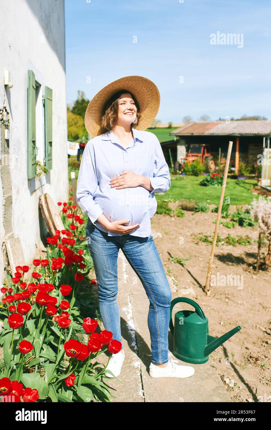Außenporträt einer glücklichen jungen schwangeren Frau, die einen schönen sonnigen Tag auf dem Land genießt Stockfoto
