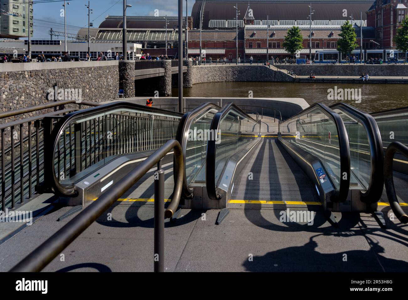 Rolltreppe führt zu einem unterwasserenen Fahrradparkplatz in der Nähe des Amsterdamer Hauptbahnhofs, Niederlande Stockfoto