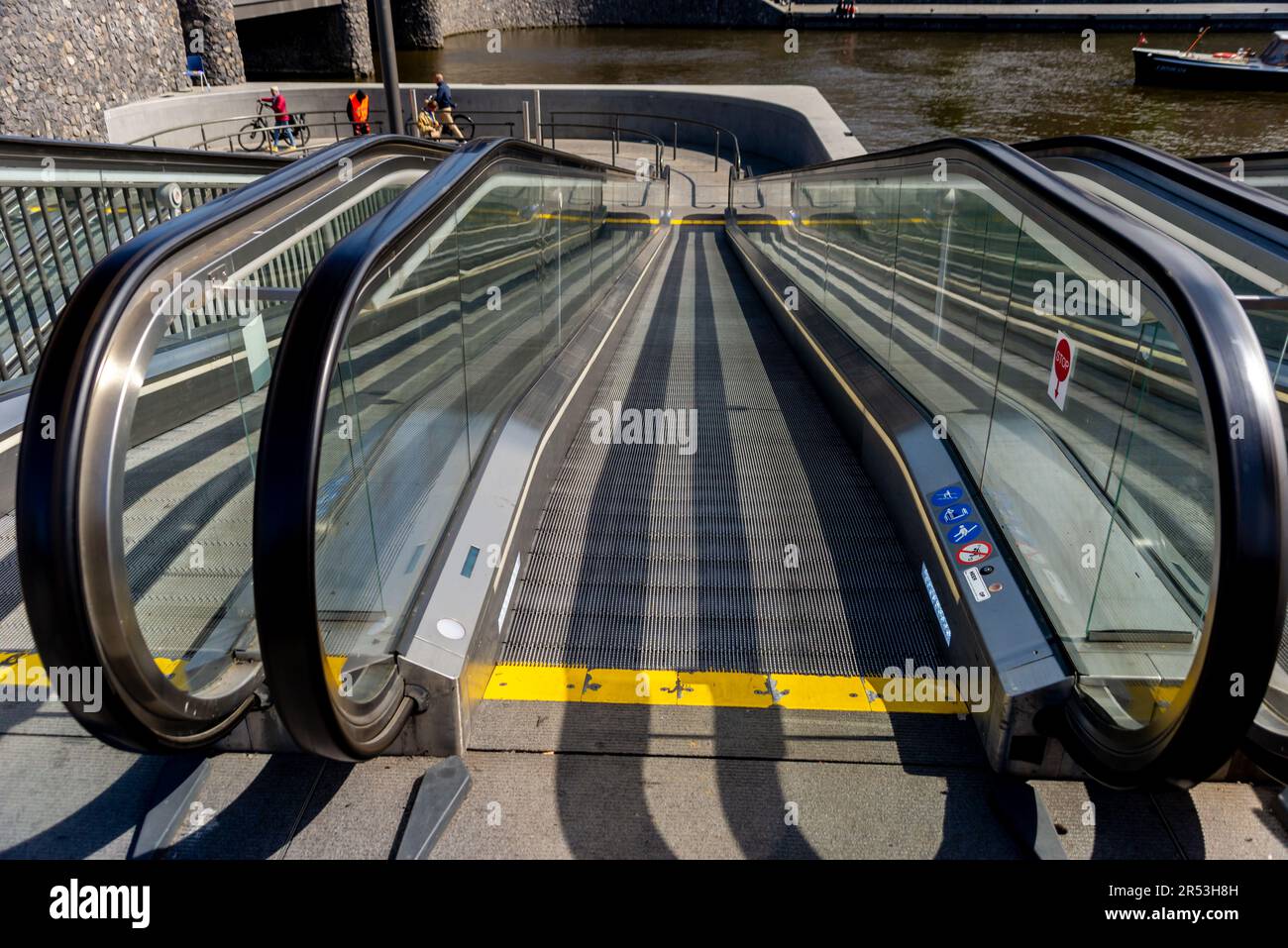 Rolltreppe führt zu einem unterwasserenen Fahrradparkplatz in der Nähe des Amsterdamer Hauptbahnhofs, Niederlande Stockfoto