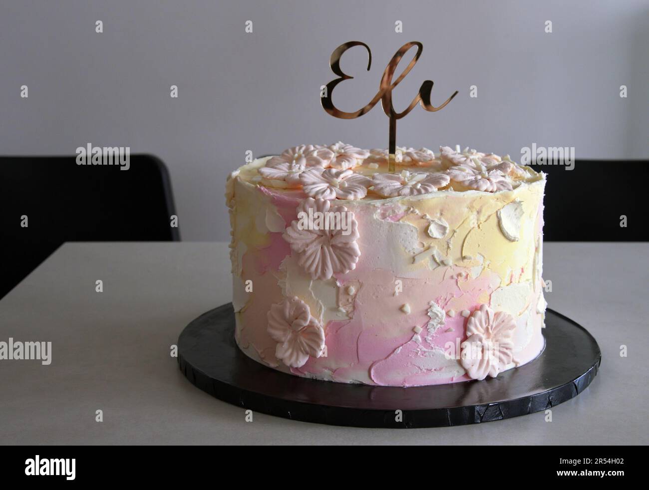 Geburtstagskuchen mit weißer Creme und goldenen Buchstaben Stockfoto