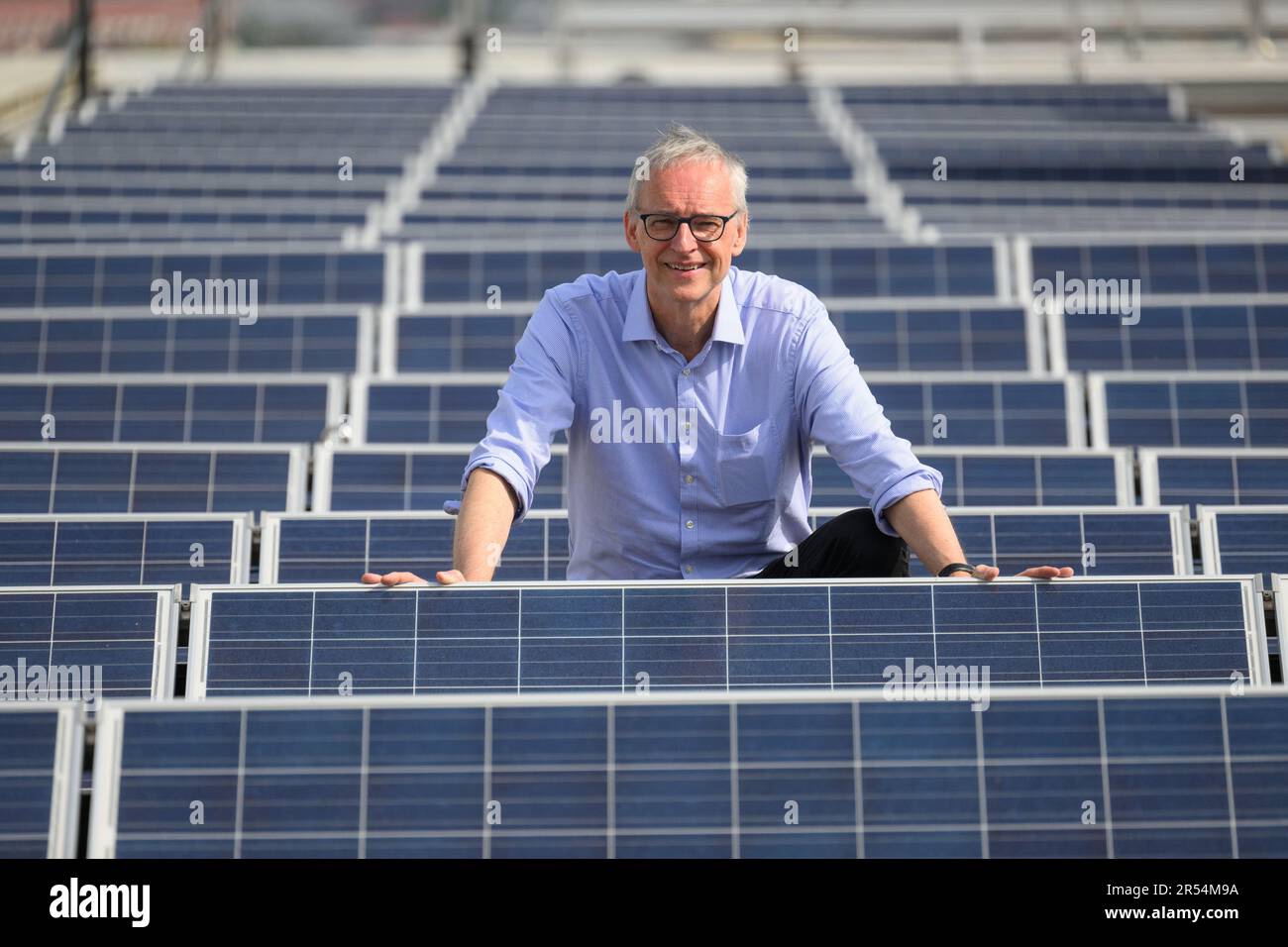 Dresden, Deutschland. 22. Mai 2023. Karl Leo, Direktor des Instituts für angewandte Physik (IAP) der TU Dresden, besticht das Dach des Hermann Krone Building inmitten von Solarmodulen. Der Leibniz-Preisträger forscht unter anderem in den Bereichen Photovoltaik und organische Elektronik. Kredit: Robert Michael/dpa/Alamy Live News Stockfoto