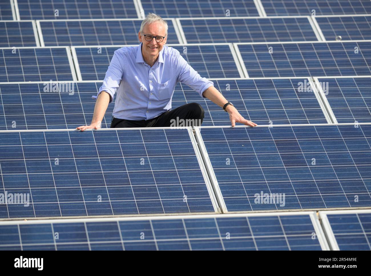 Dresden, Deutschland. 22. Mai 2023. Karl Leo, Direktor des Instituts für angewandte Physik (IAP) der TU Dresden, besticht das Dach des Hermann Krone Building inmitten von Solarmodulen. Der Leibniz-Preisträger forscht unter anderem in den Bereichen Photovoltaik und organische Elektronik. Kredit: Robert Michael/dpa/Alamy Live News Stockfoto