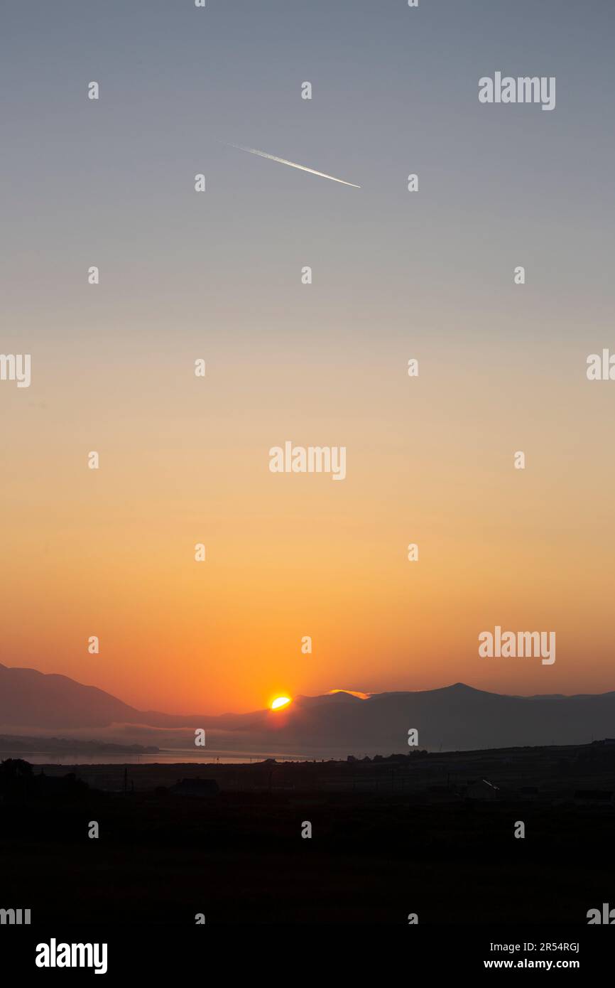Portmagee, County Kerry, Irland. 1. Juni 2023 Glorreicher Sonnenaufgang und Jet Trail über Portmagee Channel, um am ersten Junitag zu verkünden. Foto: Stephen Power/Alamy Live News Stockfoto