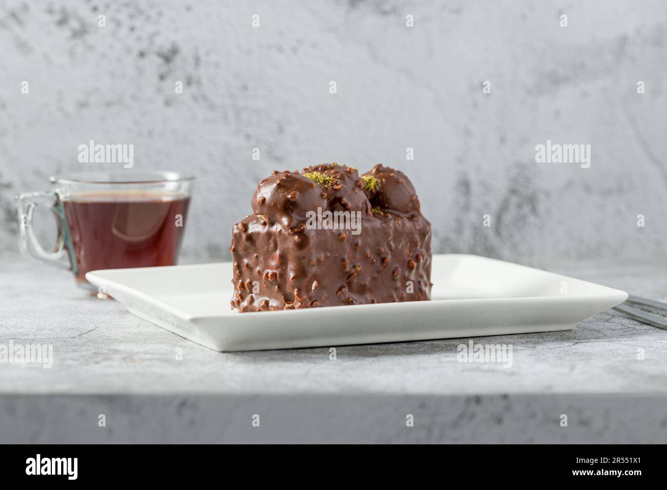 Kuchen mit Profiteroles und Tee auf einem Steintisch Stockfoto