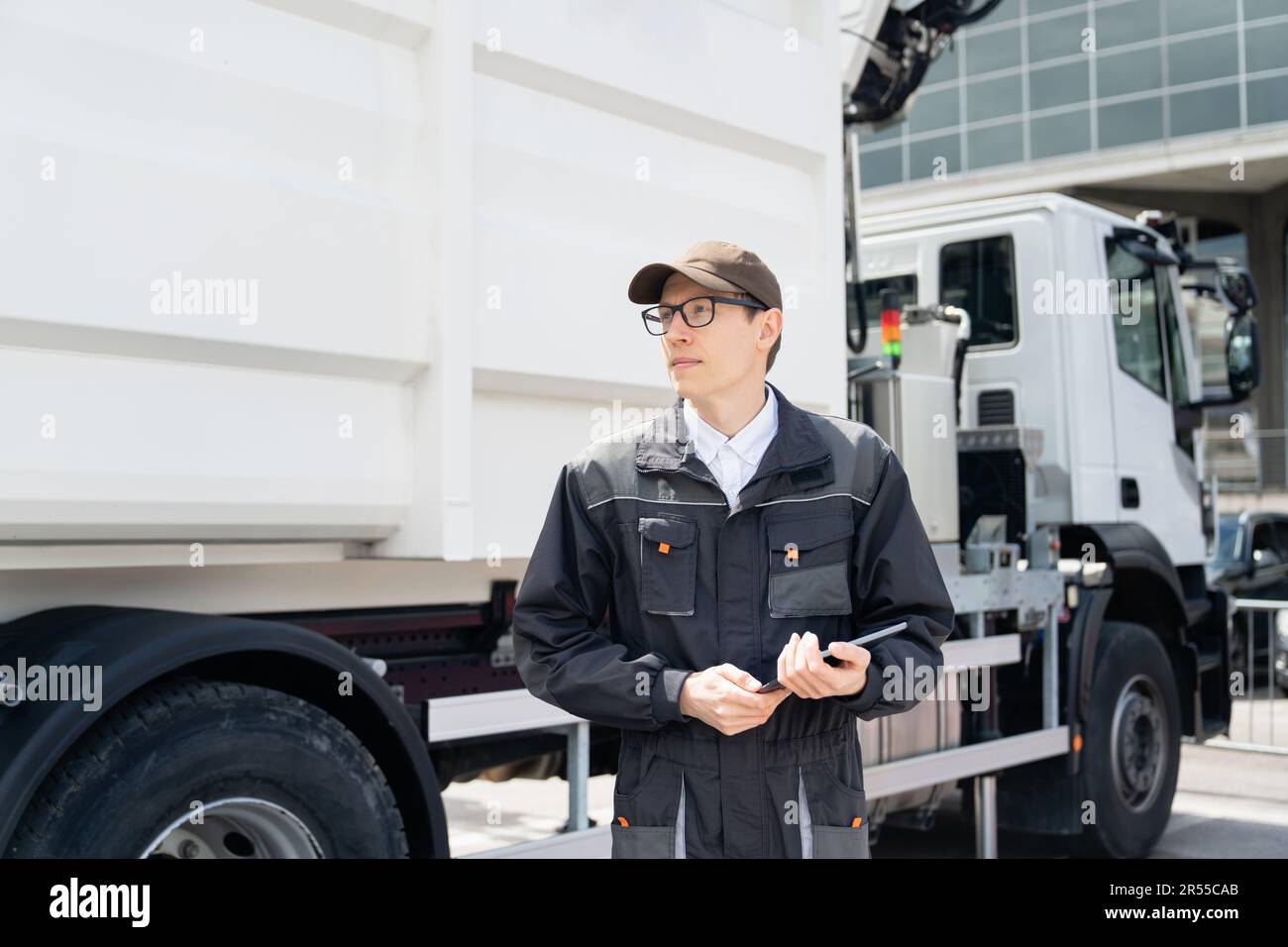Manager mit einem digitalen Tablet neben dem Müllwagen. Hochwertiges Foto Stockfoto