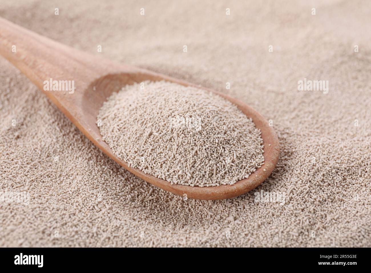 Löffel auf Stapel aktiver Trockenhefe, Nahaufnahme Stockfoto