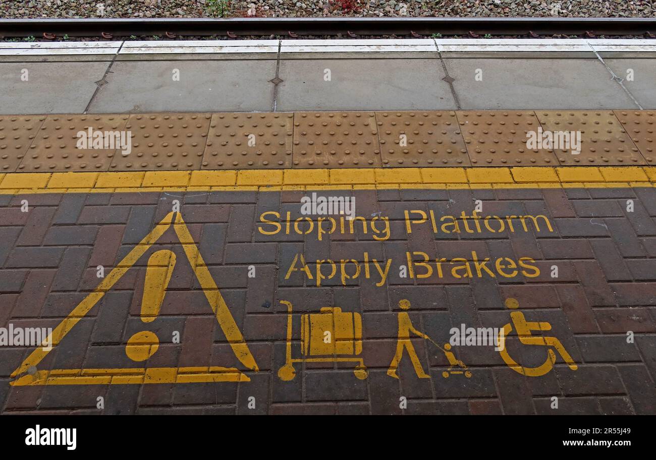 Sicherheitsmarkierungen auf einem schrägen Bahnsteig am Bahnhof Warrington Bank Quay an der West Coast Main Line warnen die Passagiere, das Gepäck zu bremsen Stockfoto