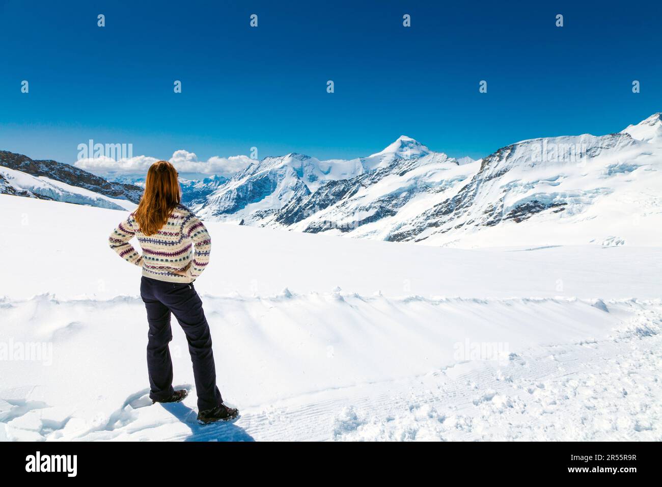 Eine Frau mit malerischem Blick auf die Berge und den Aletsch-Gletscher, der Wanderweg vom Jungfrau-Gipfel zum Mönchsjoch Hut, Schweizer Alpen, Schweiz Stockfoto
