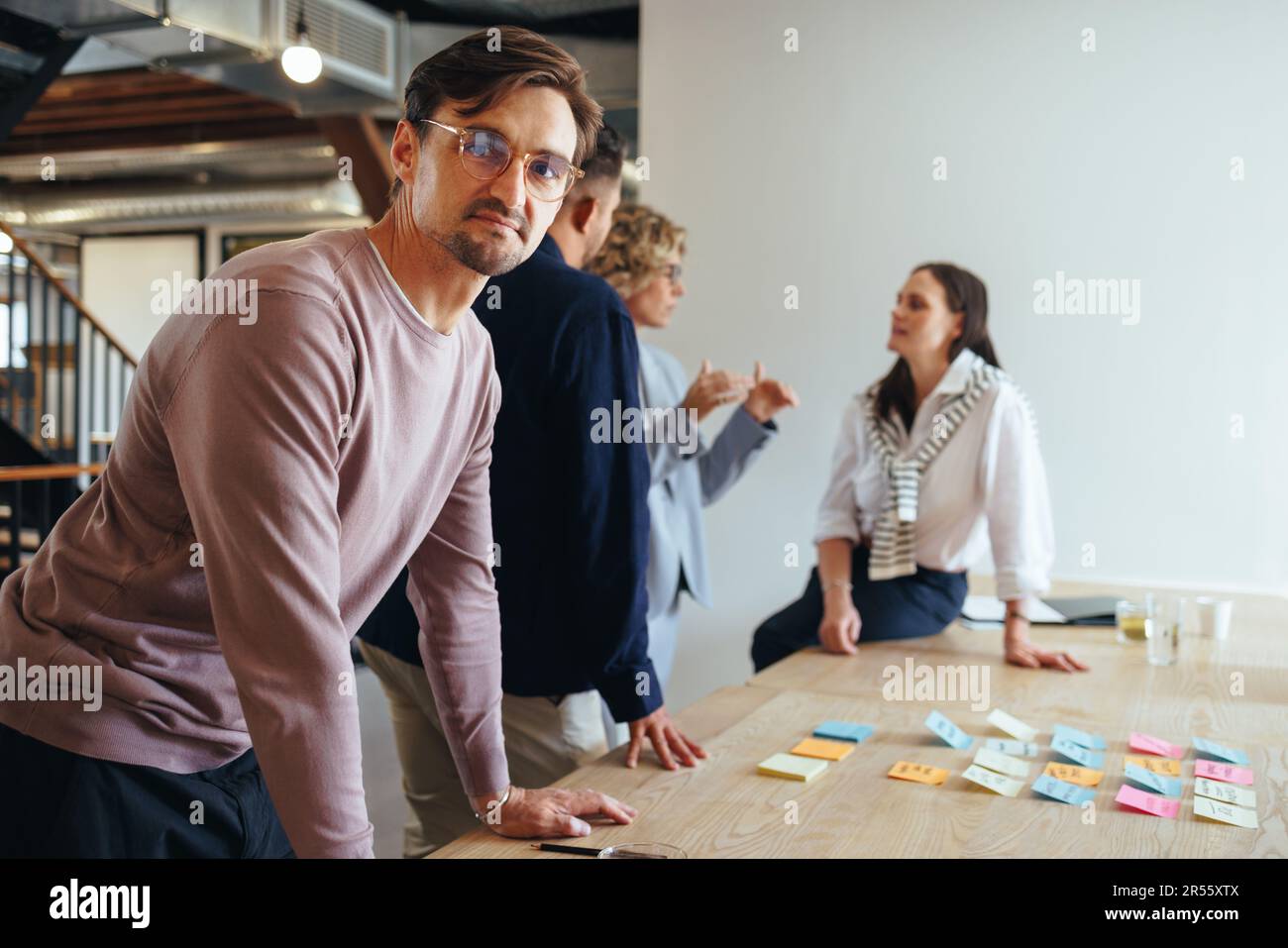 Geschäftsmann, der ein Meeting mit seinem Team in einer Marketingagentur hat. Kreative Geschäftsleute beim Brainstorming in einem Büro. Gruppe von Fachleuten, die arbeiten Stockfoto