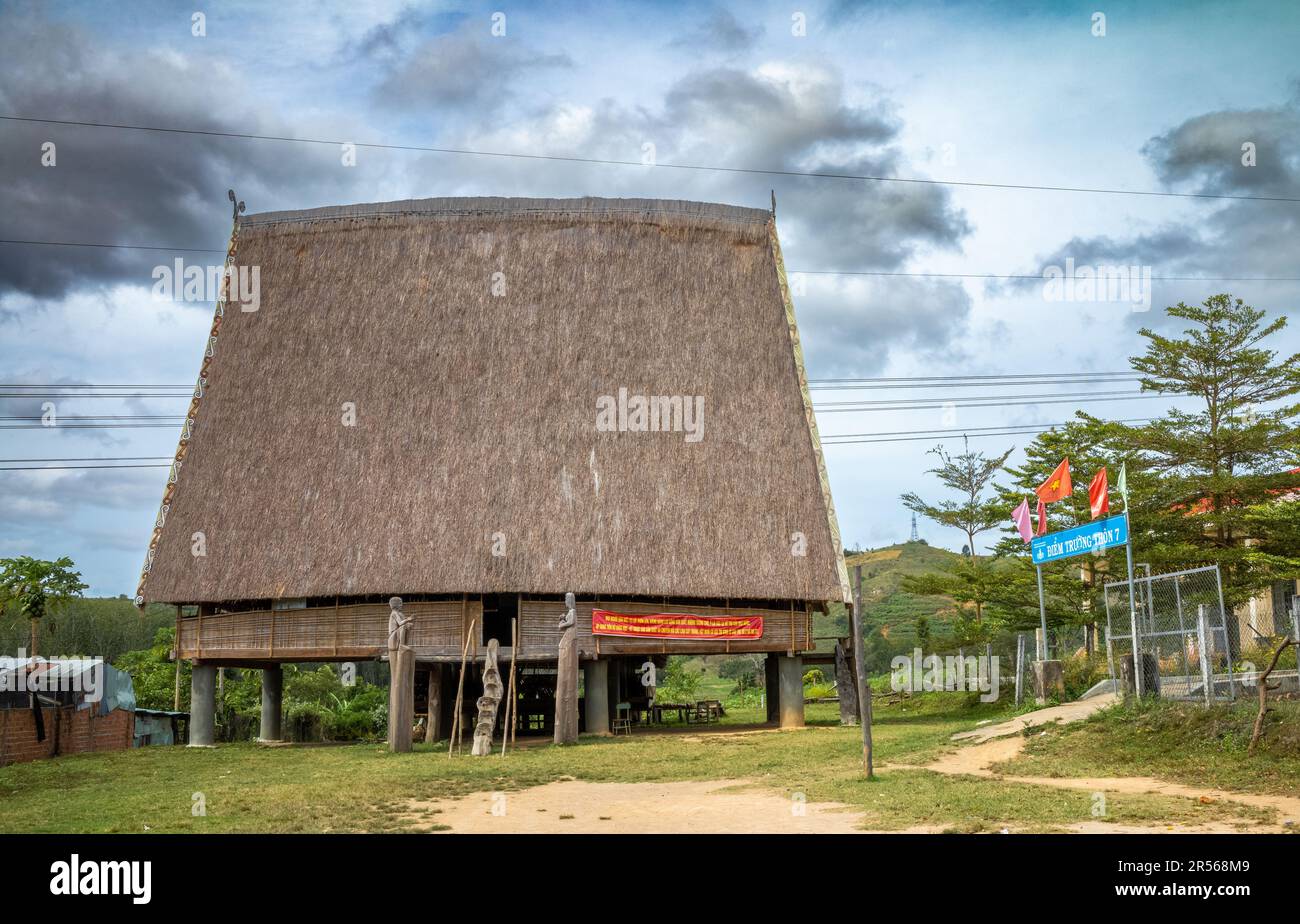 Ein traditionelles „nha rong“, oder Kulturhaus, mit seinem segelähnlichen Strohdach, das der ethnischen Minderheit Bahnar neben dem Dorf gehört Stockfoto