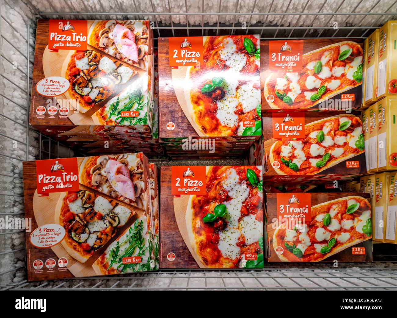 Italien - 21. Mai 2023: Gefrorene vorgekochte Pizzas in einer Pappschachtel, dekoriert mit auffälligen Fotos von Pizzas, die in einem Kühlschrank des italienischen Supermarkts zum Verkauf angeboten werden Stockfoto
