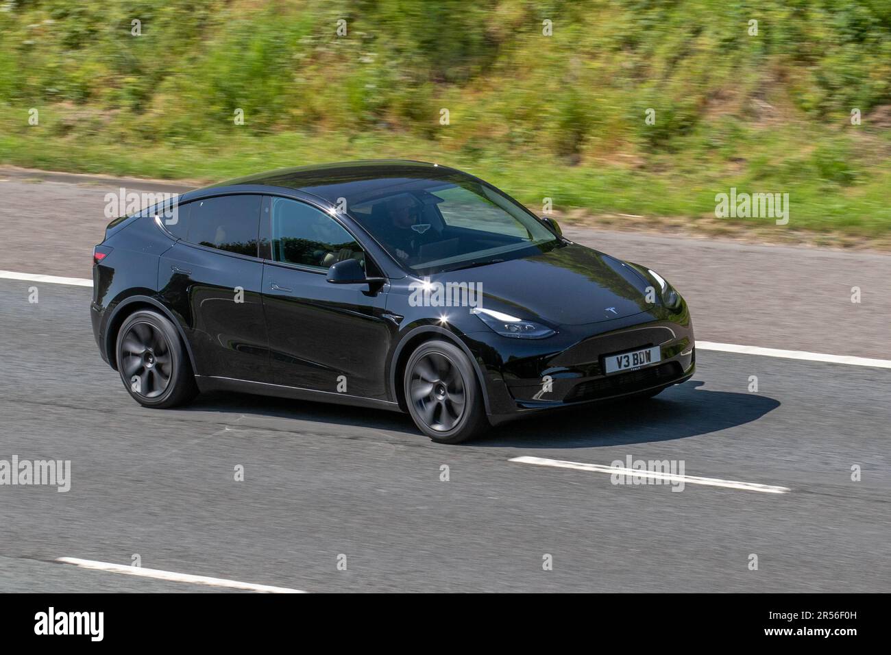 2023 Black Tesla Model Y mit Heckantrieb; Fahrt auf der Autobahn M61, Großbritannien Stockfoto