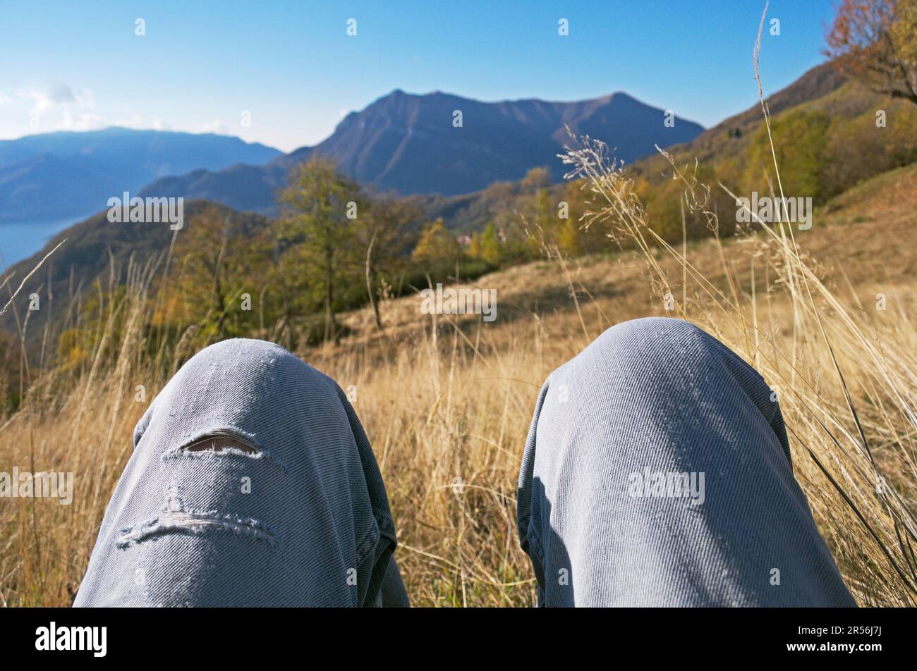 Sie lag auf einer Bergwiese mit gebeugten Beinen Stockfoto