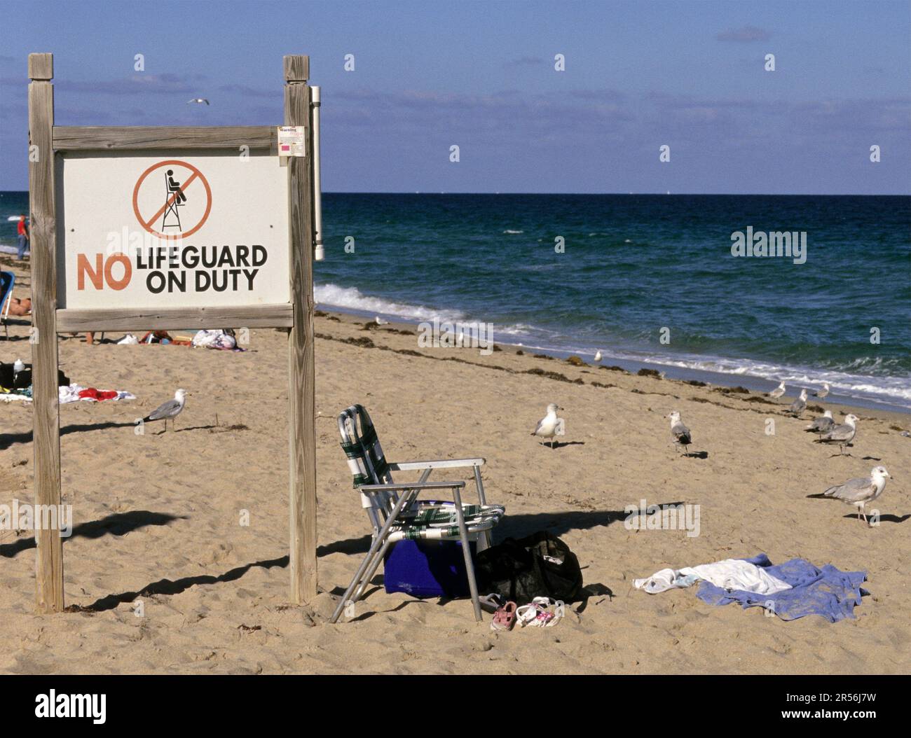 Schild mit der Aufschrift „No Lifeguard on Duty“ und leerer Dolar am Strand von Fort Lauderdale Florida USA Stockfoto