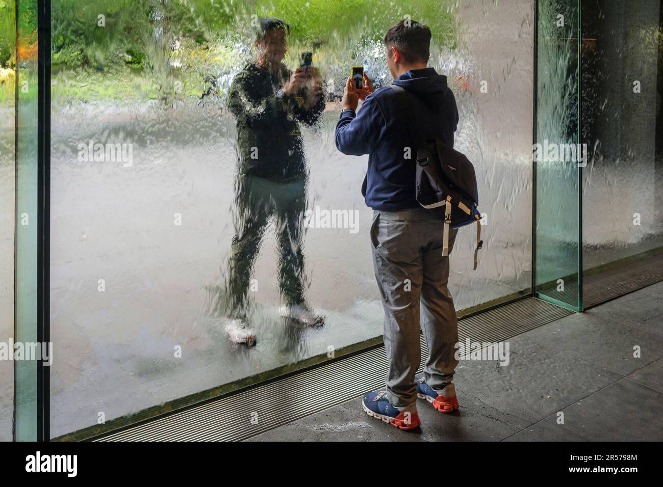 Besucher fotografieren sich gegenseitig durch die Waterwall in der National Gallery of Victoria, Melbourne, Australien Stockfoto