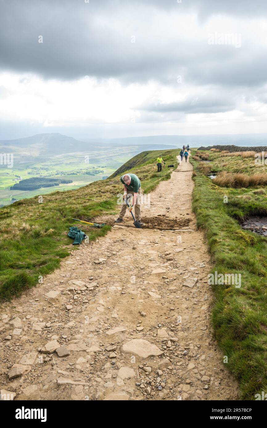 Freiwillige und Park Ranger pflegen die Wanderwege und trockenen Mauern auf dem Gipfel von Whenside, einem der drei Gipfel von Yorkshire. Stockfoto