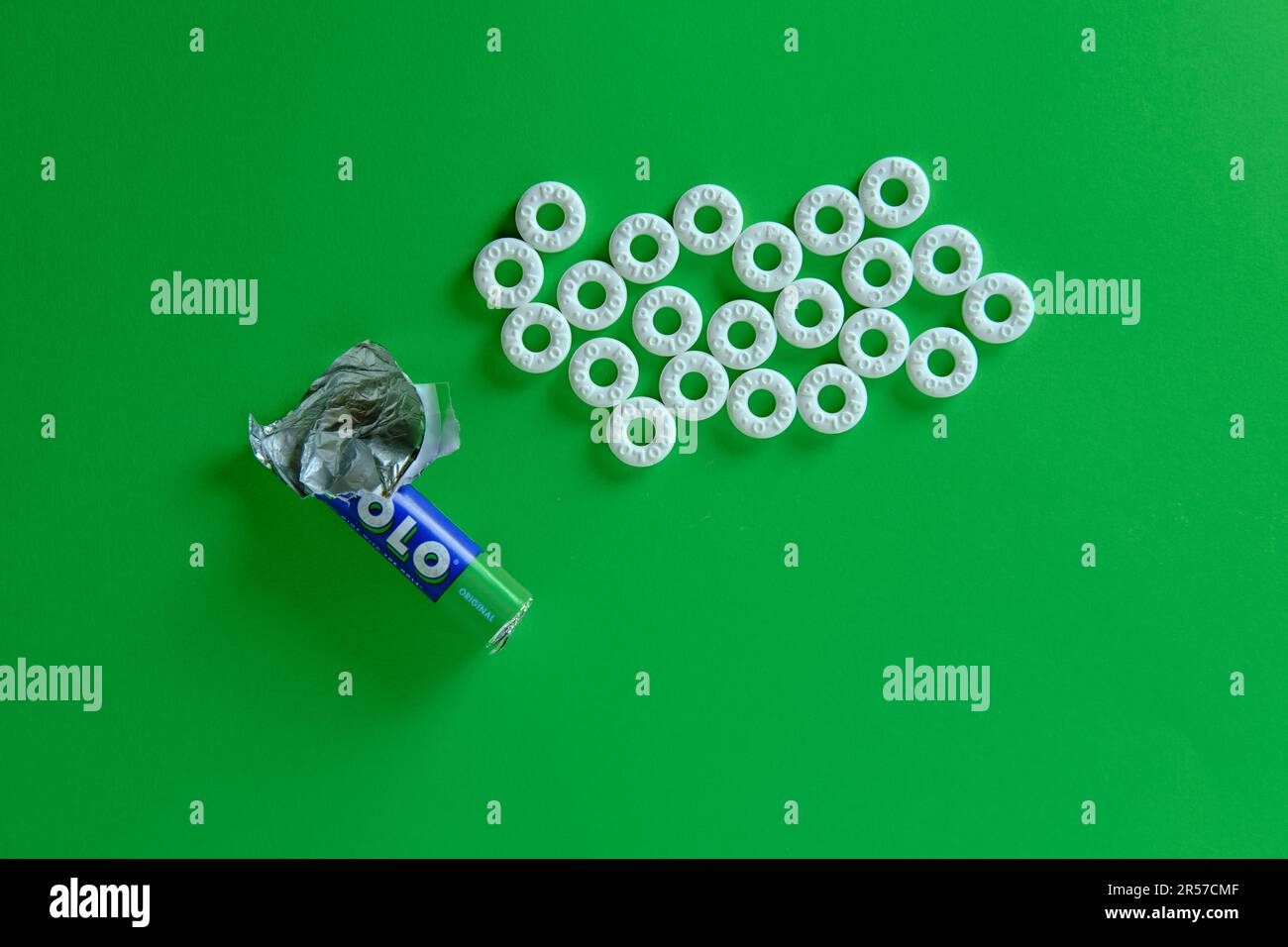 Ein Haufen Polominzbonbons vor einem glatten grünen Hintergrund. Ansicht von oben nach unten. Stockfoto