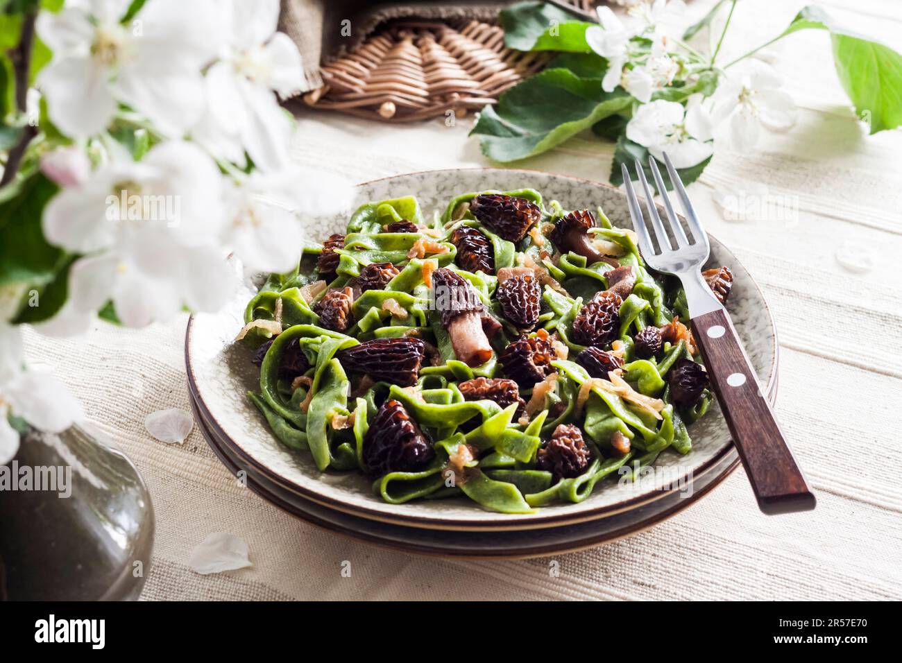 Hausgemachte Nudelgerichte mit grüner Brennnessel und gebratenen Frühlingsmorchel-Pilzen auf einem Teller Stockfoto