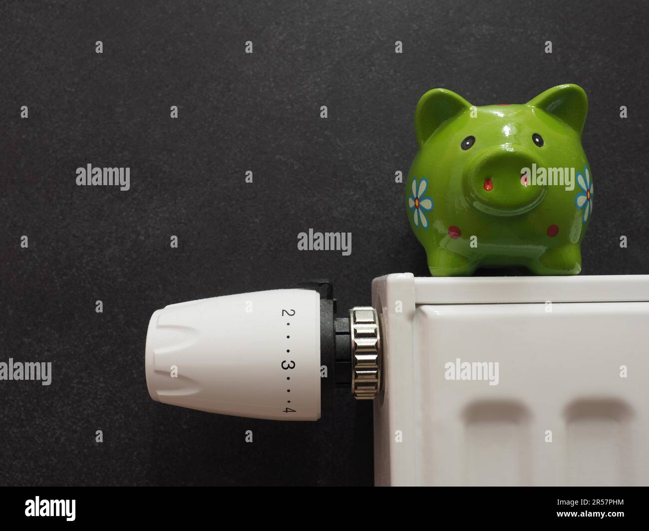 Nahaufnahme des Heizthermostats, Energiesparen Konzept mit einem Sparschwein, Platz für Ihren Text, Stoppen Sie den Verbrauch von fossilen Brennstoffen Stockfoto