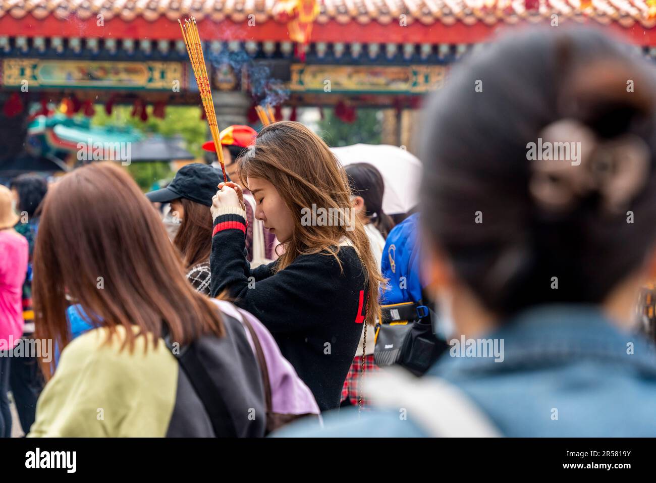Junge Chinesen Beten Im Wong Tai Sin Tempel An, Hongkong, China. Stockfoto
