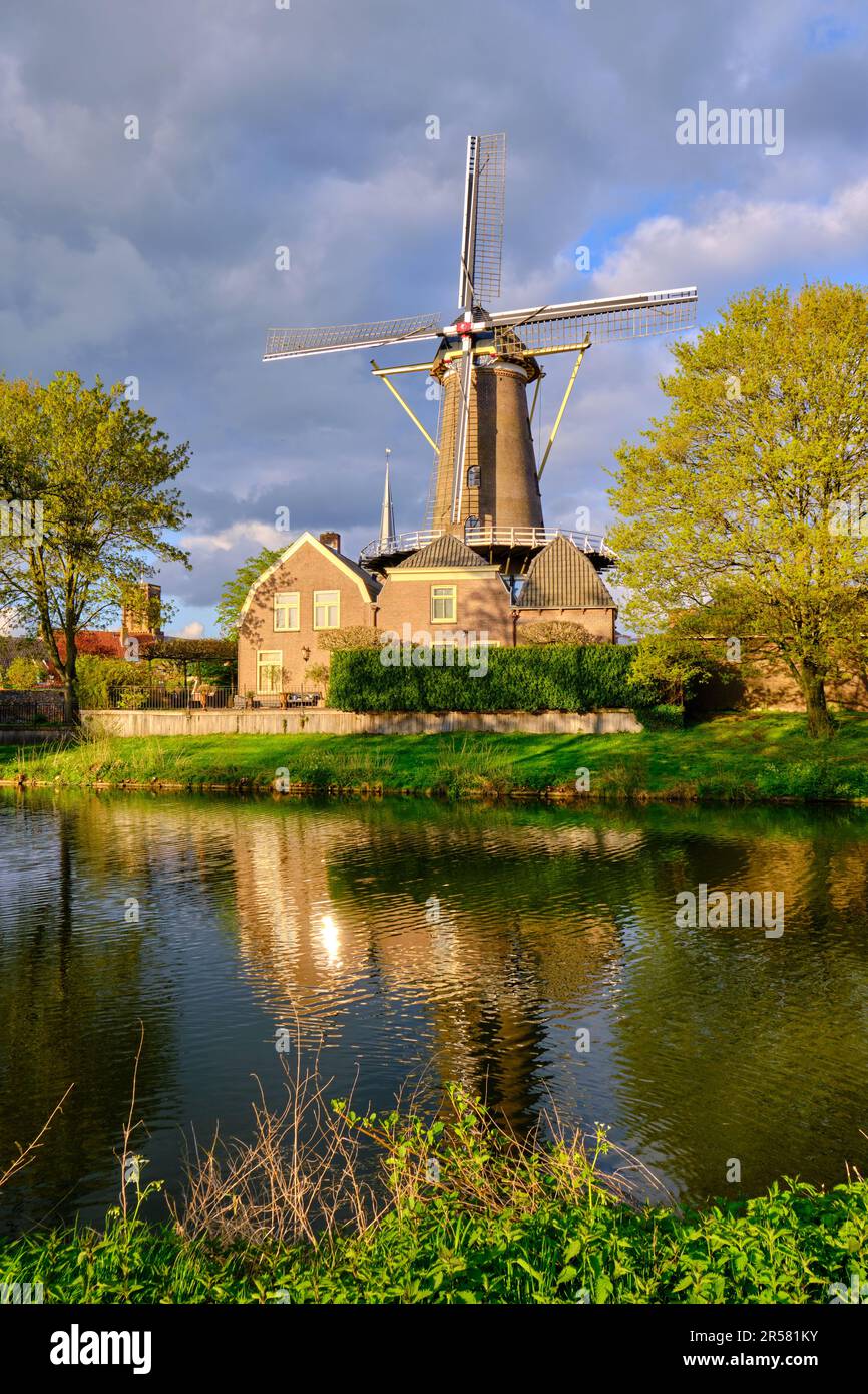 Culemborg, Niederlande - April 25 2023. Windmühle „de Hoop“ in der niederländischen Provinz Gelderland am sonnigen Frühlingstag. Reflexionen im Wasser. Stockfoto