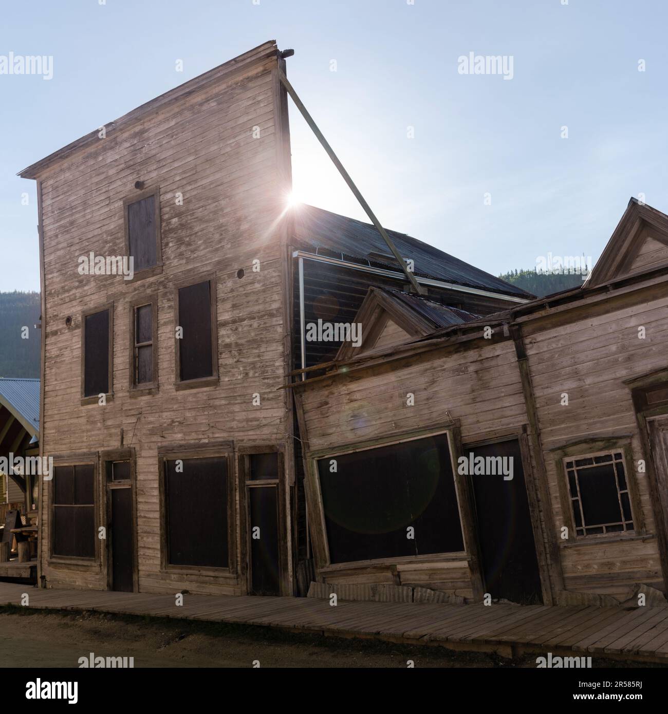 Historische Ausblicke in Dawson City im Sommer mit Blick auf alte, sinkende Gebäude. Berühmte „Kissing Buildings“ im Goldrausch, Bergbaustadt. Stockfoto