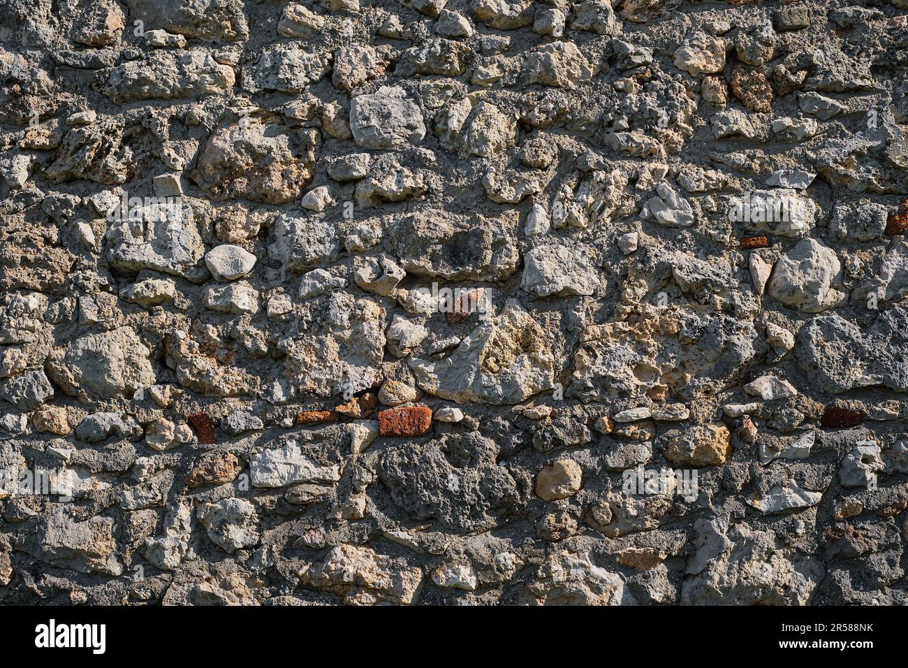 Das Konzept eines Hintergrunds aus rohem Stein, die Mauer eines alten Hauses in den Bergen. Ideen für das Innere natürlicher Materialien Stockfoto