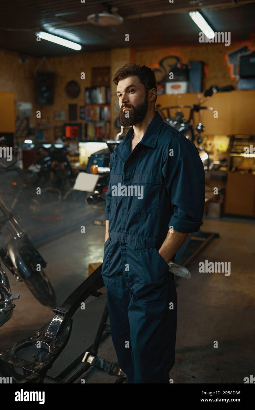 Porträt eines gutaussehenden, seriösen Reparaturwerkers, der Overalls in der Werkstatt trägt Stockfoto