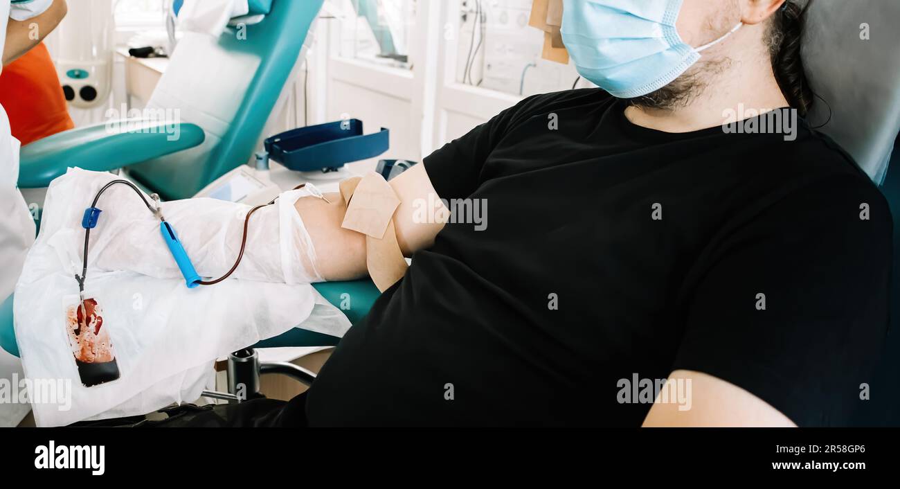 Mann mittleren Alters spendet Blut im medizinischen Labor. Der Blutspender spendet Blut für die lebensrettende und medizinische Forschung. Internationaler Tag Der Blutspende. Stockfoto