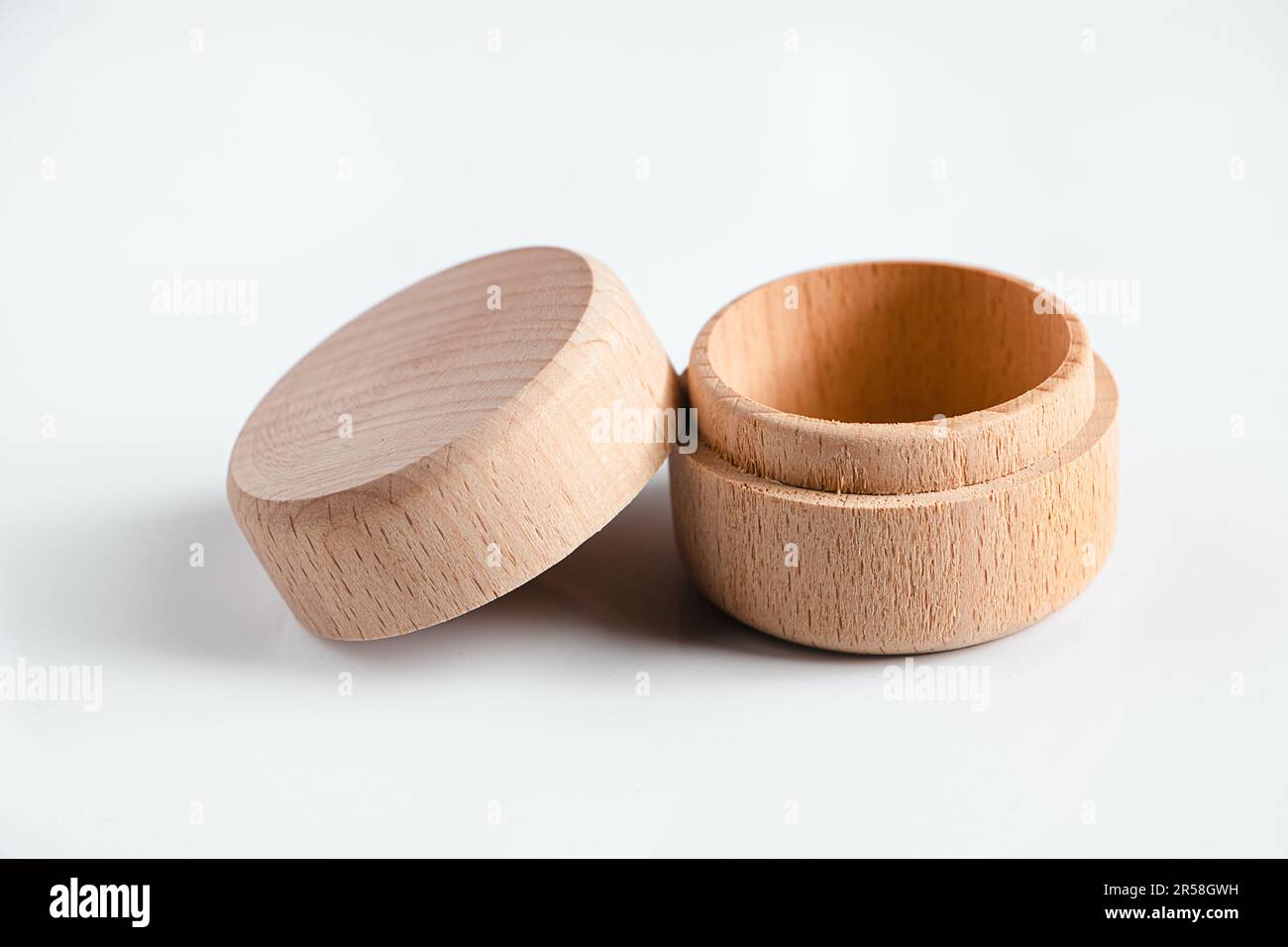 Kleine runde Holzbox auf weißem Hintergrund. Öffnen Sie die Aufbewahrungsbox für kleine Gegenstände. Stockfoto