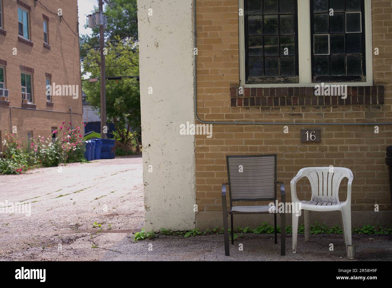 Zwei Stühle vor dem rustikalen Backsteingebäude, Winnipeg, Manitoba, Kanada Stockfoto