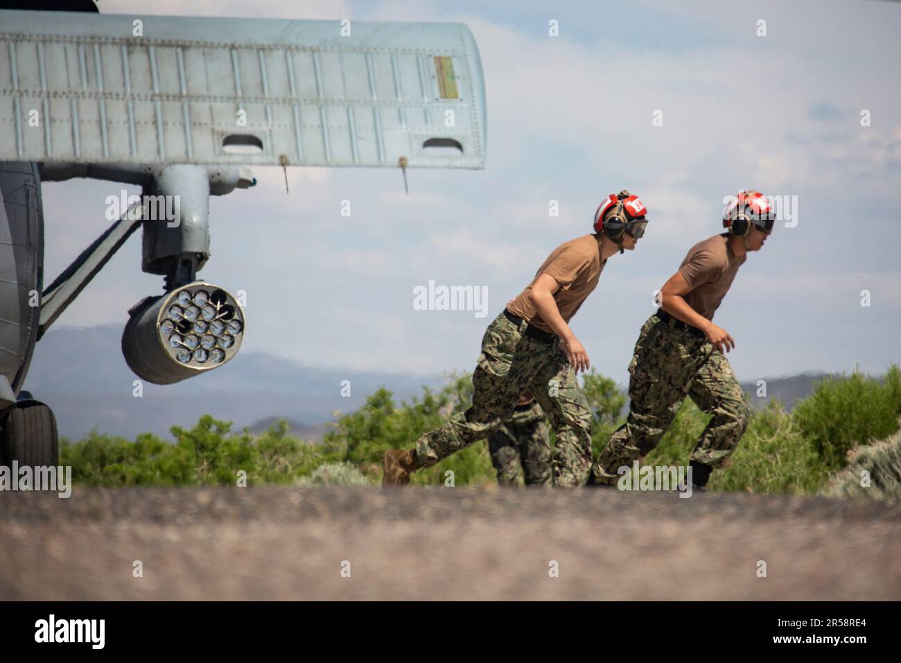 FALLON, Nevada (16. Mai 2023) Aviation Ordnanceman 2. Class Alexander Gardner, aus McMinnville, Oregon, links, Und Aviation Ordnanceman Airman Michael Tirado, aus San Juan, Puerto Rico, rannte, nachdem er die Sicherheitsnadel an einem LAU-61 G/A Digital Rocket Launcher in einem MH-60s Seahawk Helicopter gezogen hatte, der dem Helicopter Sea Combat Squadron (HSC) 4 in der Naval Air Station (NAS) Fallon während Air Wing Fallon zugewiesen wurde. Air Wing Fallon ist Teil des Ausbildungszyklus vor dem Einsatz für die Flugzeugträger-Flügel der Navy. HSC-4, zusammen mit VFA-2, VFA-192, VFA-113, VFA-97, VAQ-136, VAW-113 und HSM-78 bestehen aus CVW-2 und sind getrennt Stockfoto