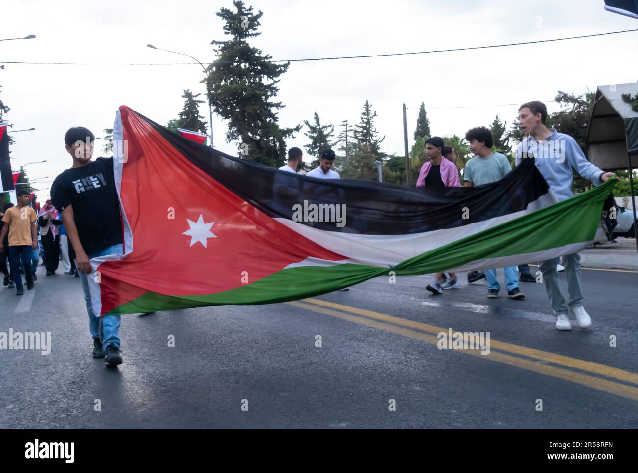Viele junge Leute mit jordanischer Flagge, die die Hochzeit von Prince auf den Straßen in der Innenstadt von Amman feiern. 1. Juni 2023. Amman Jordan Stockfoto