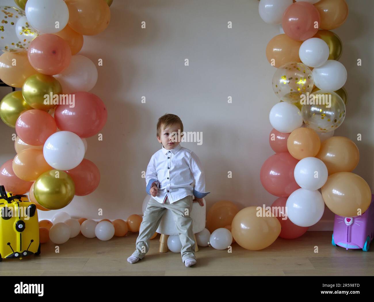 Süßes kleines Kleinkind feiert Geburtstag mit Ballons Stockfoto
