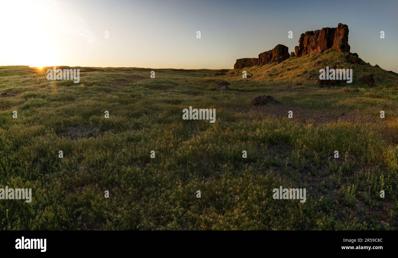 Basalt butte erhebt sich über Wüstengrasland bei Sonnenuntergang, Seep Lakes Wildlife Area, Washington, USA Stockfoto