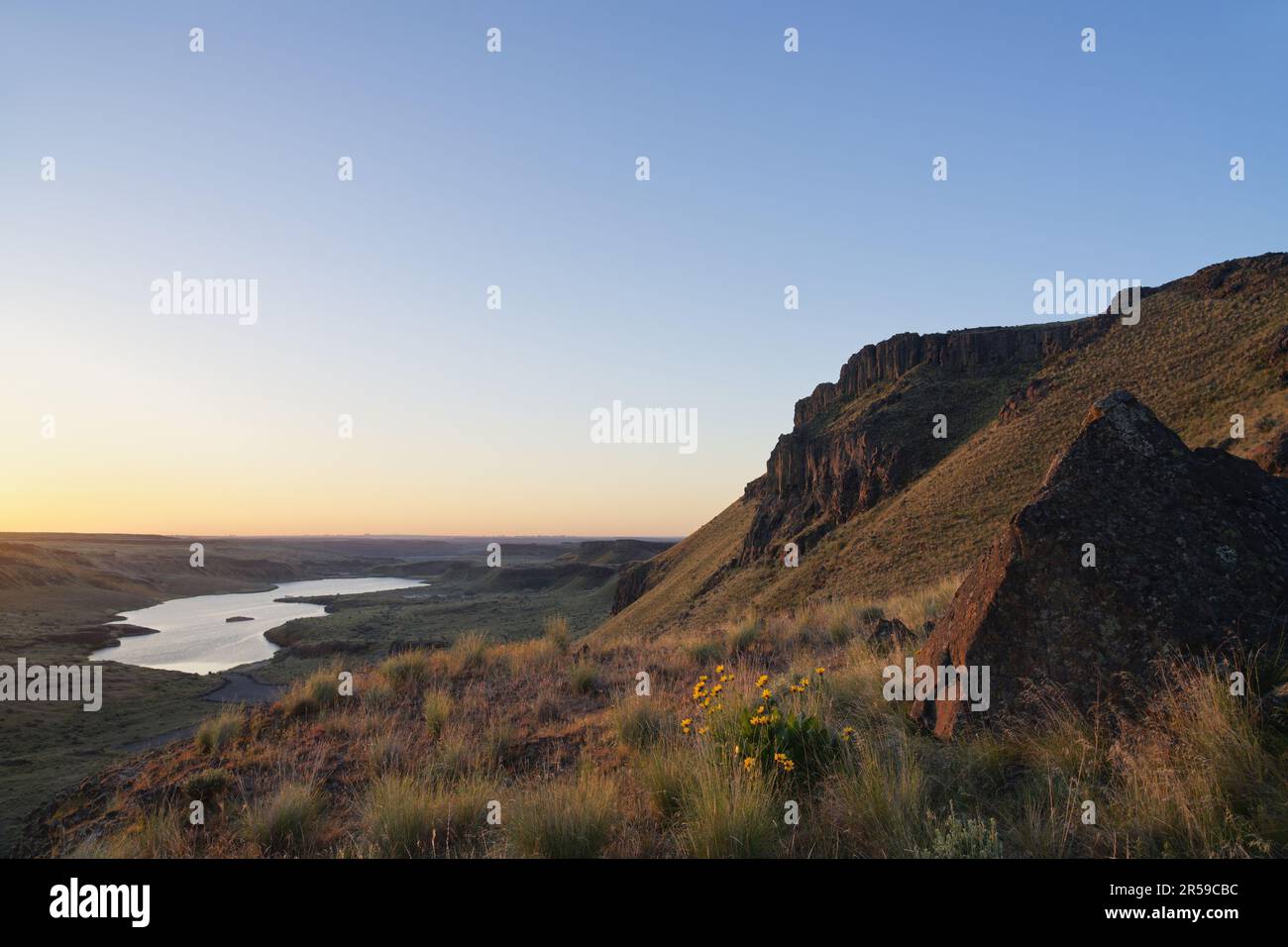 Die über dem Corral Lake aufragenden Basaltklippen und die bei Sonnenuntergang in der Desert Wildlife Area, Washington, USA, gespreizten Felsformationen Stockfoto