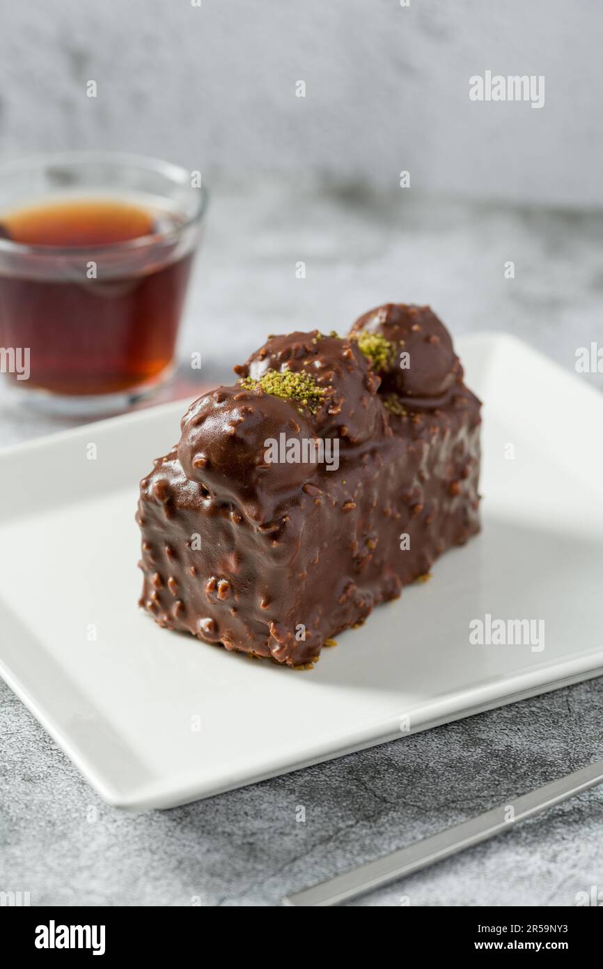 Kuchen mit Profiteroles und Tee auf einem Steintisch Stockfoto