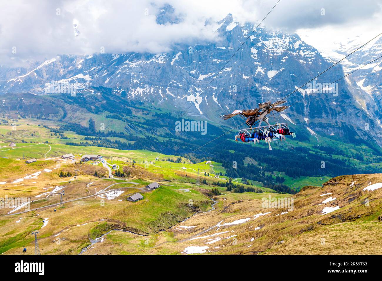 Menschen an der ersten Glider-Seilrutsche auf dem Gipfel des ersten Berges, Wetterhorn im Hintergrund, Schweiz Stockfoto