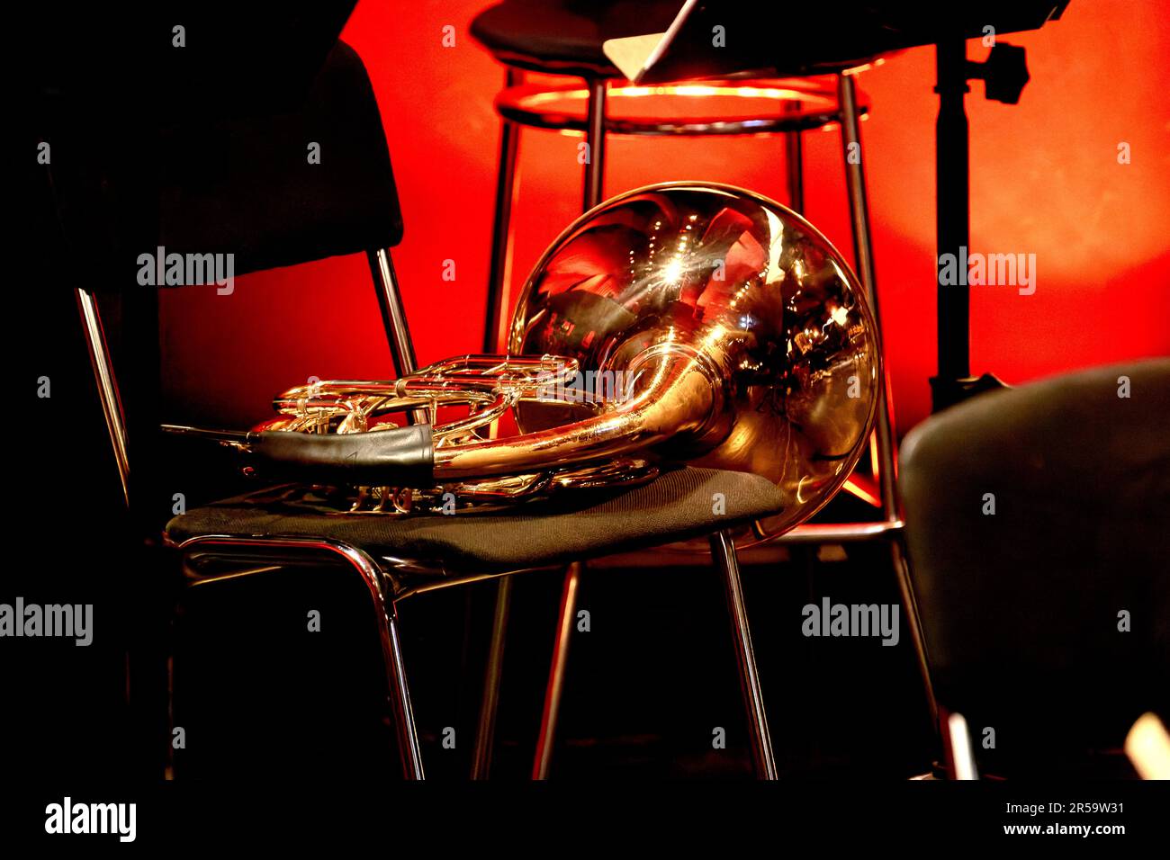 Das Bild eines Musikinstrumentehorns aus Windmessing liegt auf einem Stuhl im Theater Stockfoto