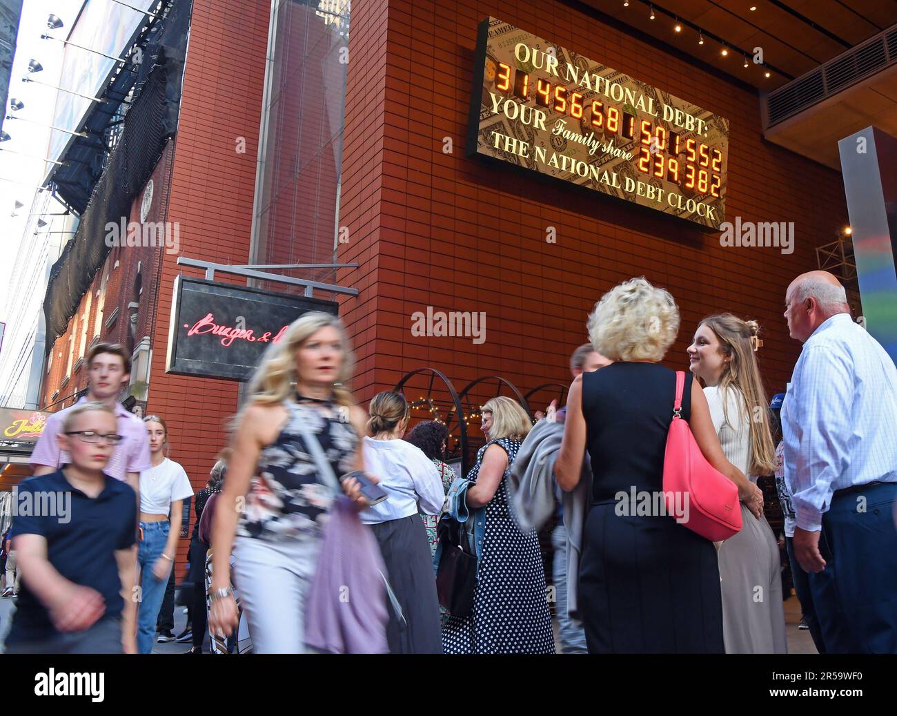 New York, USA. 1. Juni 2023. Fußgänger laufen am 1. Juni 2023 in New York, USA, an der National Debt Clock vorbei. Nach monatelangem Parteienarmkampf, die USA Der Kongress genehmigte das Gesetz zur Anhebung der Schuldenobergrenze Amerikas nach der Verabschiedung des Senats am späten Donnerstag, dem 103. Mal seit 1945, und ermöglichte der Regierung, einen Schuldenausfall durch weitere Kreditaufnahme zu verhindern. Kredit: Li Rui/Xinhua/Alamy Live News Stockfoto