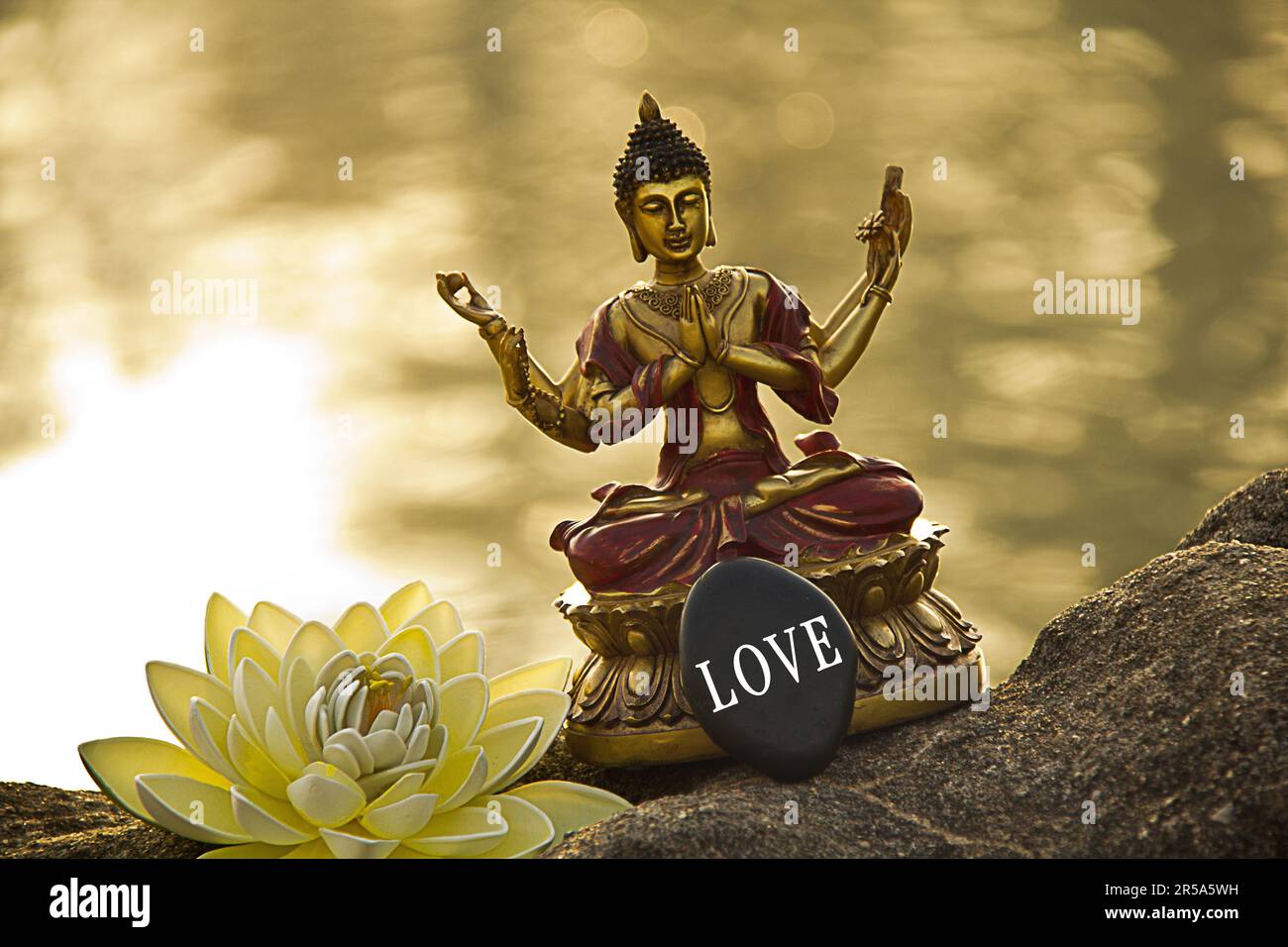 Sechsarmige buddha am Wasser mit Lotos Blume am Morgen, Stein mit Liebe Stockfoto
