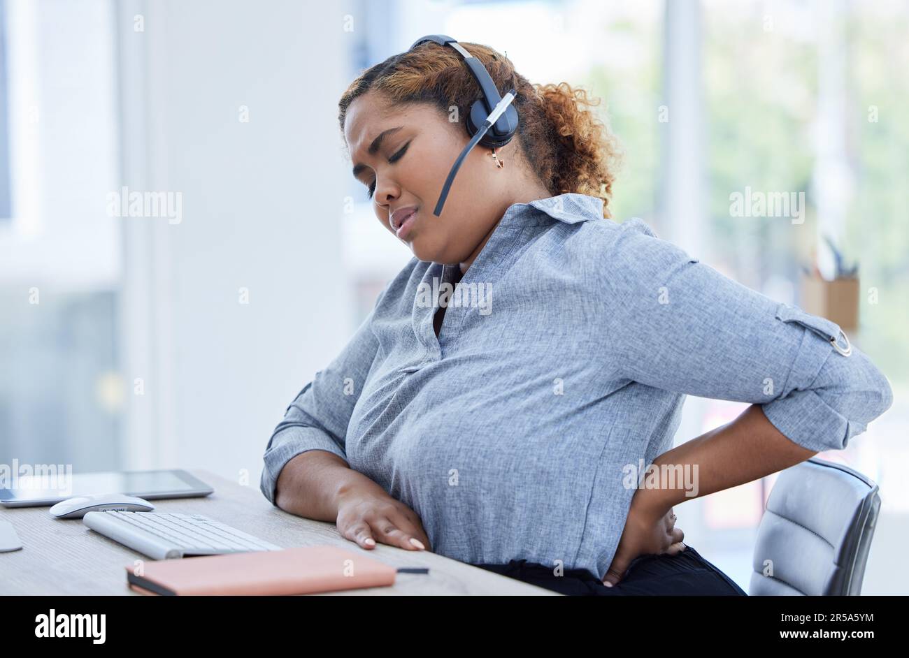Callcenter, Rückenschmerzen und Frauenberatung für den Kundendienst, während Sie im Büro an Arthritis oder Entzündung leiden. Wirbelsäule, Rückenschmerzen und weiblich Stockfoto
