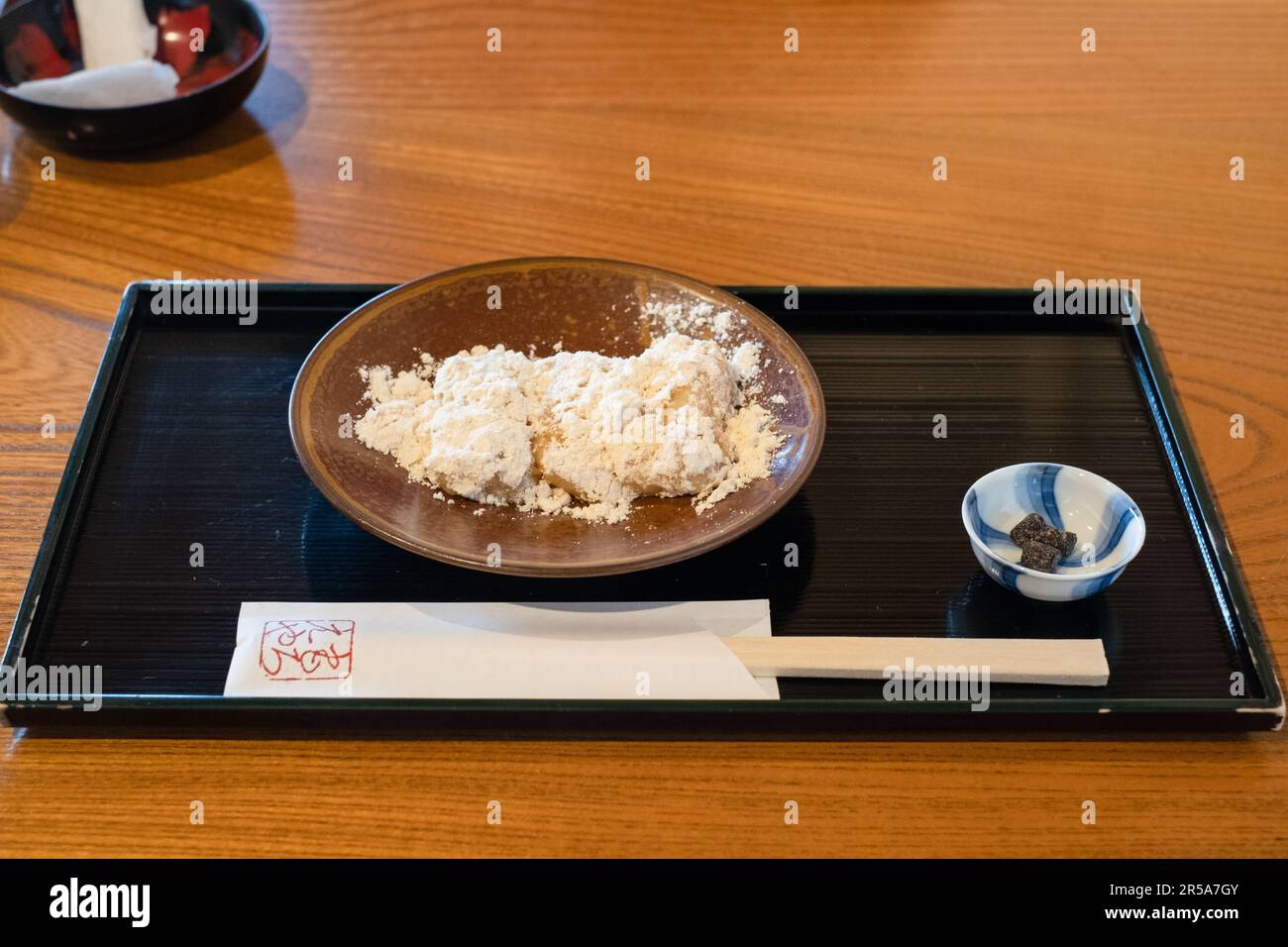 Abekawa Mochi, in heißes Wasser getauchter Mochi mit gesüßtem gelbem Sojabohnenmehl, Kanazawa, Japan. Stockfoto