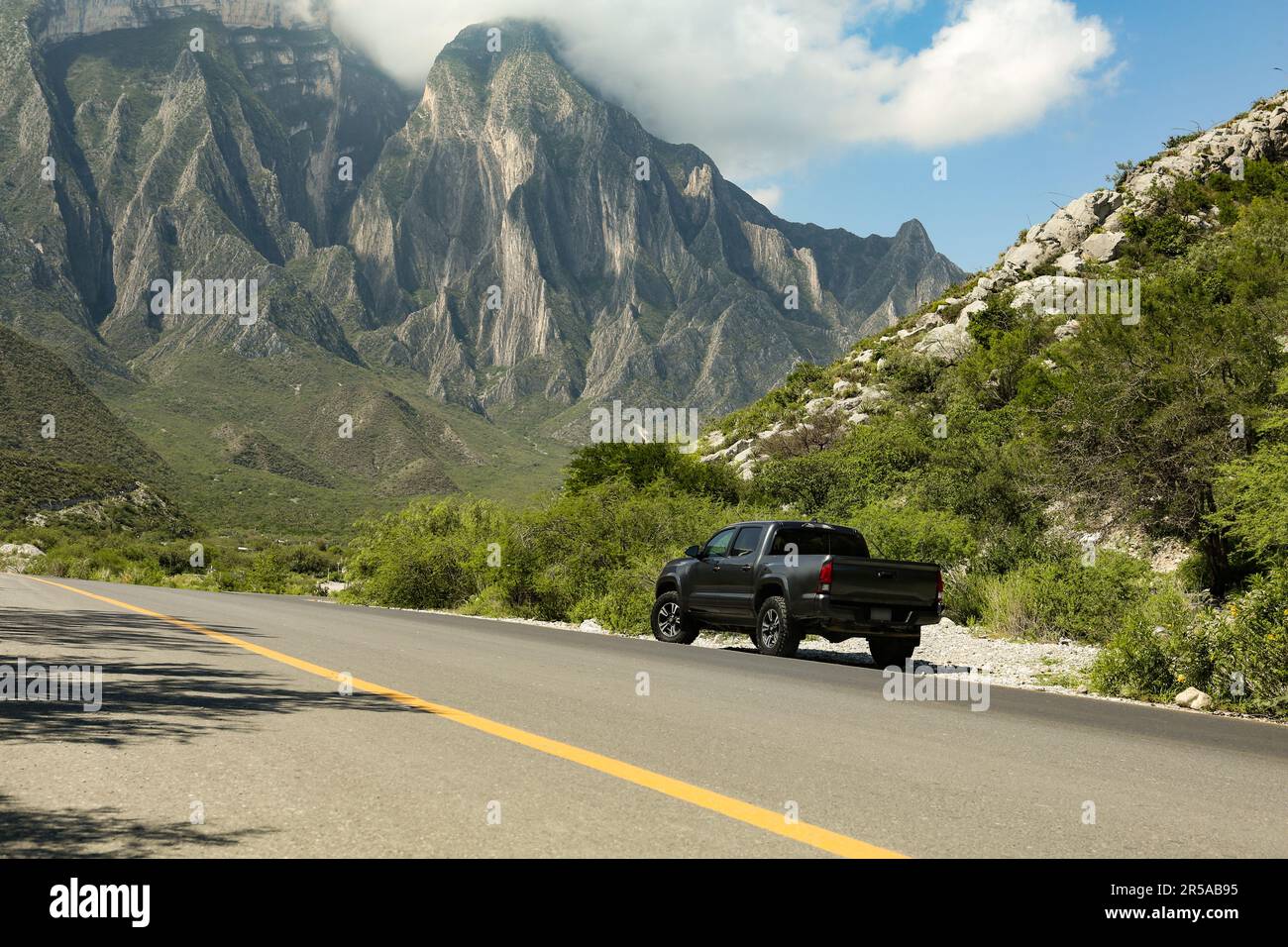 Schwarzes Auto in der Nähe von wunderschönen Bergen und Straßen im Freien Stockfoto